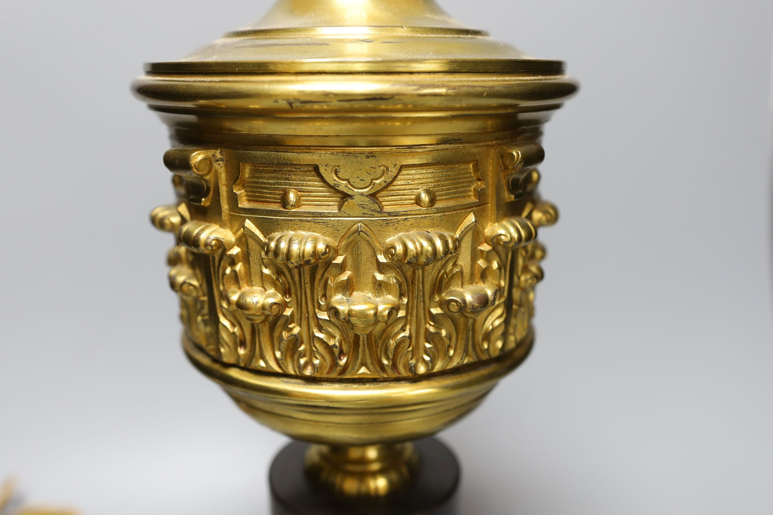 A brass urn lamp, on painted terracotta stepped base, 48cm